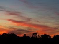Wolkenschleier am Abendhimmel glühen in leuchtendem Rot
